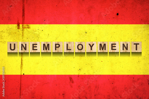 Unemployment. The inscription on wooden blocks on the background of the Spain flag. Unemployment growth. Business. photo