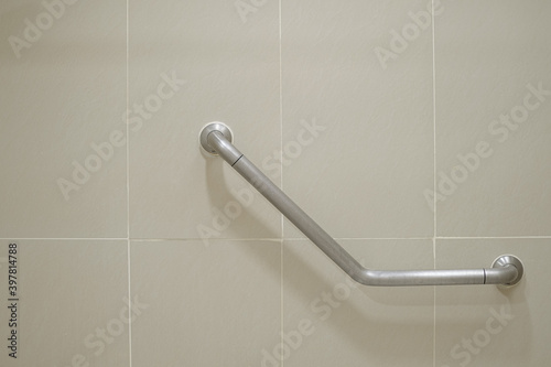 Close up handrail on the tile wall for support disabled and elder people. Safety concept.