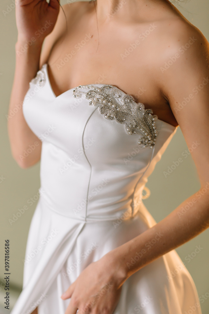 Young brunette woman in a white wedding dress on front the hand