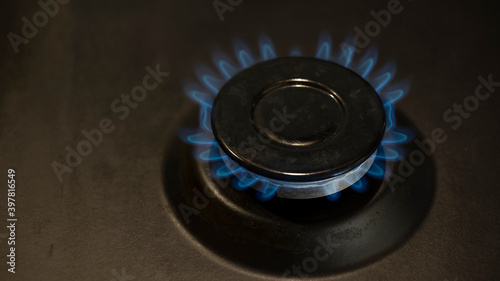 lit gas burner on the gas surface of an anthracite-colored stove © Andrey