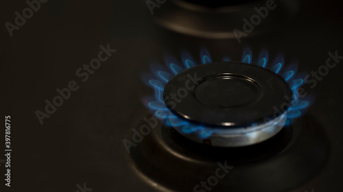 lit gas burner on the gas surface of an anthracite-colored stove © Andrey
