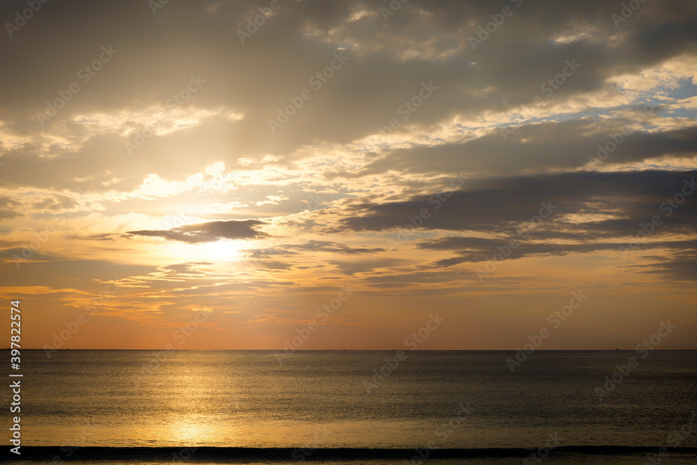 Beautiful sunset over the clam sea with cloud and sky background. Sunset over tropical beach. Nature summer concept. Peak sunset over sea with yellow light reflect in cloud. Beautiful sunset over the clam sea with cloud and sky background. Sunset over tropical beach. Nature summer concept. Peak sunset over sea with yellow light reflect in cloud.