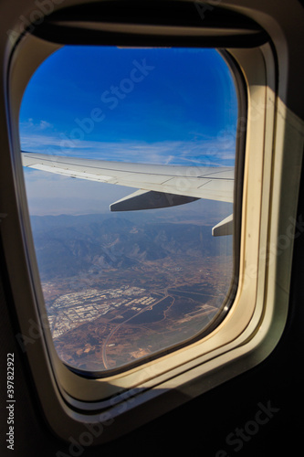 View from the porthole window flying airplane on the airplane wing. Flying and traveling concept