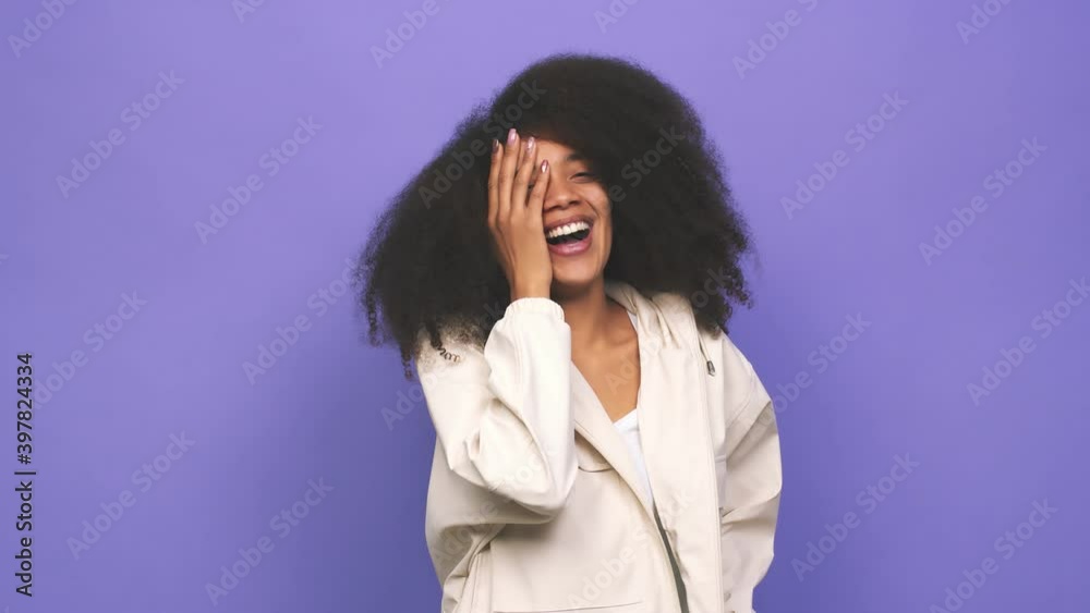 Young african american curly woman shocked covering mouth with hands Young african american curly woman shocked covering mouth with hands