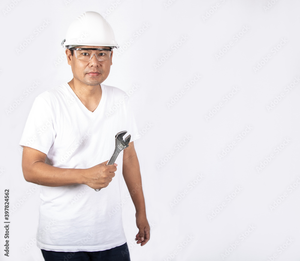 Portrait of a Asian male worker in protection glasses and helmet with copy space. Industrial technician man holding a wrench on white background Portrait of a Asian male worker in protection glasses and helmet with copy space. Industrial technician man holding a wrench on white background