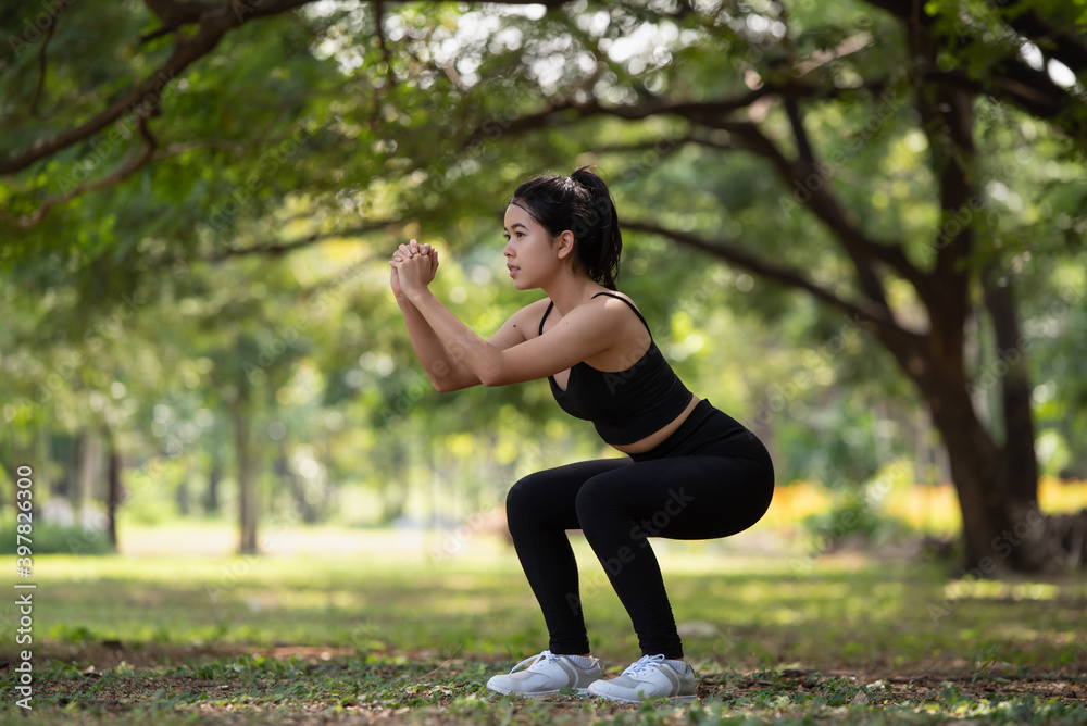 Young Asian woman doing stretching warm up before exercise outdoors in park, sport and healthy lifestyle concept Young Asian woman doing stretching warm up before exercise outdoors in park, sport and healthy lifestyle concept