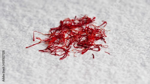 A pile of saffron threads, autumn crocuses, on the table with various spices. Saffron, red. Cooking ingredient. Twirling spices on a bright background. 4K