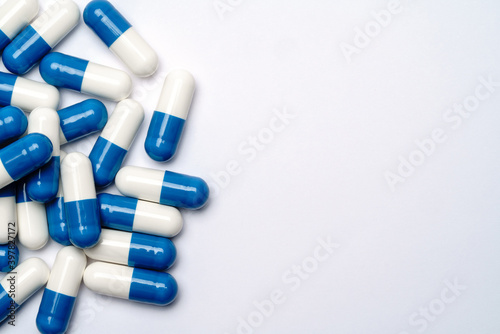 Heap of pills capsules over light grey background