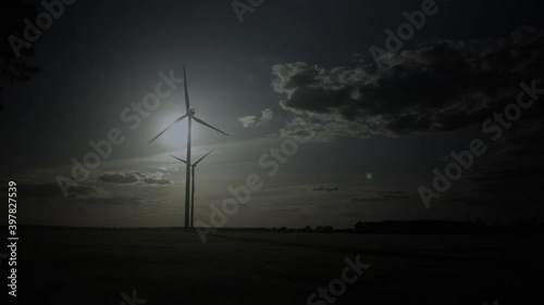 Wind Turbines Spinning With Bright Moon In Background At Night. - wide shot photo