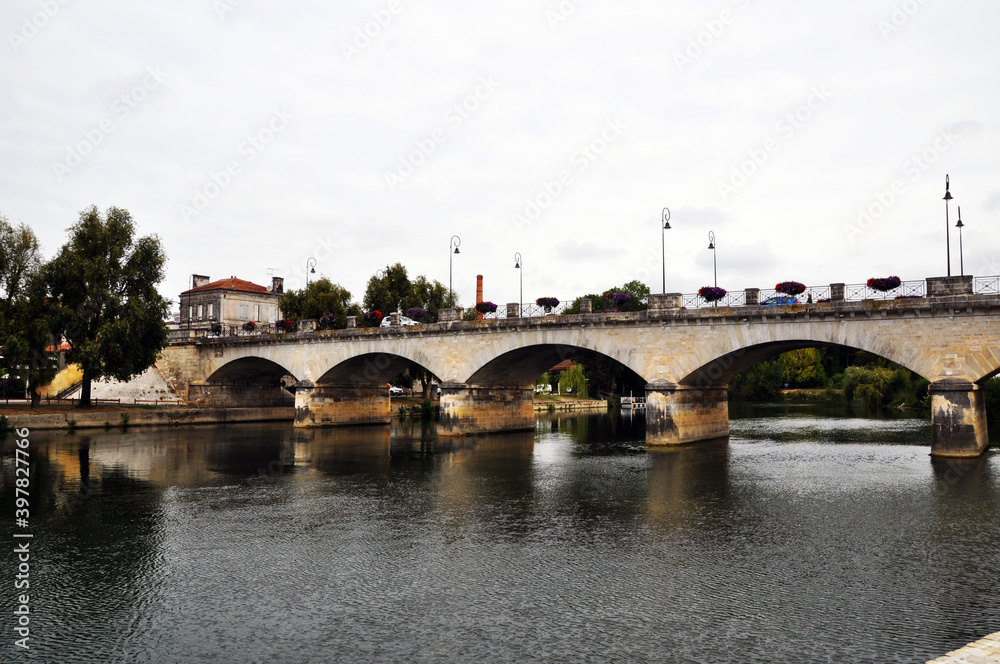 View of the Charente River. And a stone bridge across the river. Arched bridge NEF.