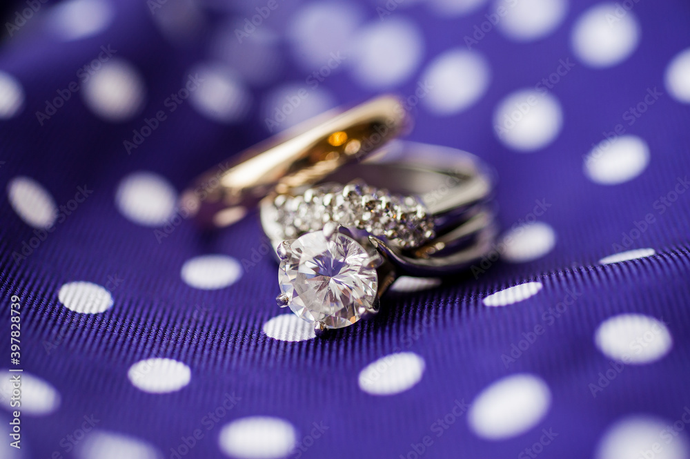 wedding rings on purple polka dot fabric