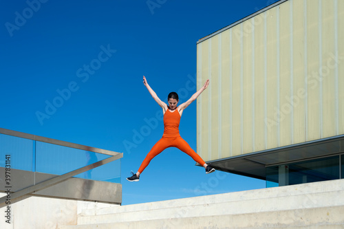 woman wearing sportswear jumping in the air  urban exercise.
