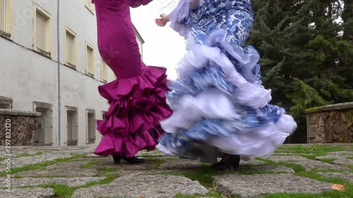 Two women dancing with typical Andalusian flamenco dress.