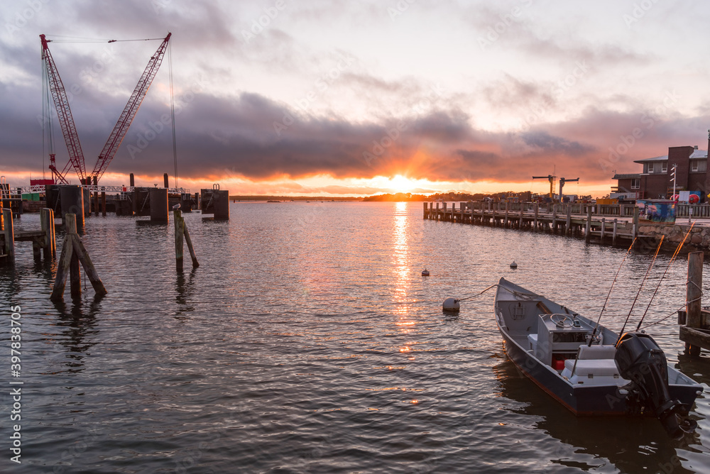 Fototapeta premium Majestic sunset over a harbour and a ferry terminal. Falmouth, Cape Cod, MA, USA.