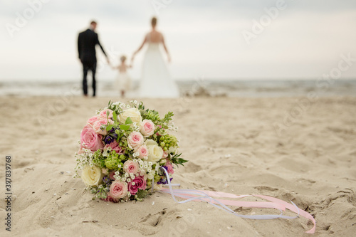 Familie bei einer Strandhochzeit mit Brautstrauß