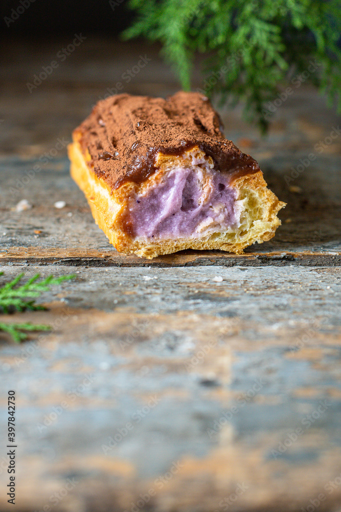 Fototapeta premium eclairs chocolate-covered in chocolate berry cut cream profiteroles ready to eat on the table healthy meal snack ingredient top view copy space for text food background rustic