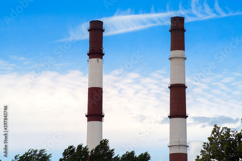 Two factory chimneys against a blue sky. Smoke emissions were stopped by the inspection due to exceeding toxic standards.
