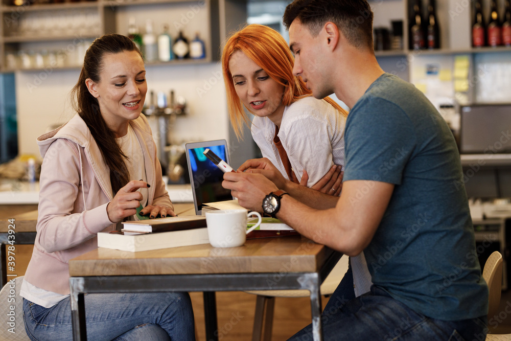 Group of university students hangout in college cafe library and preparing for lecture.	