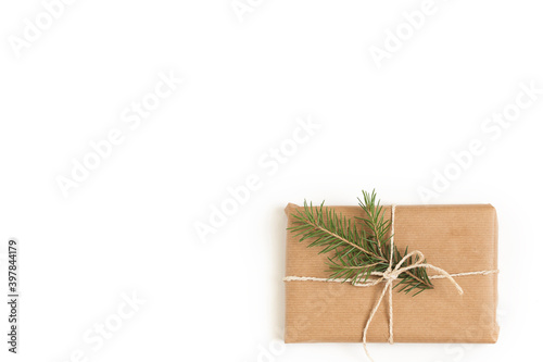 Gift box tied with a rope with a spruce branch on a white background.