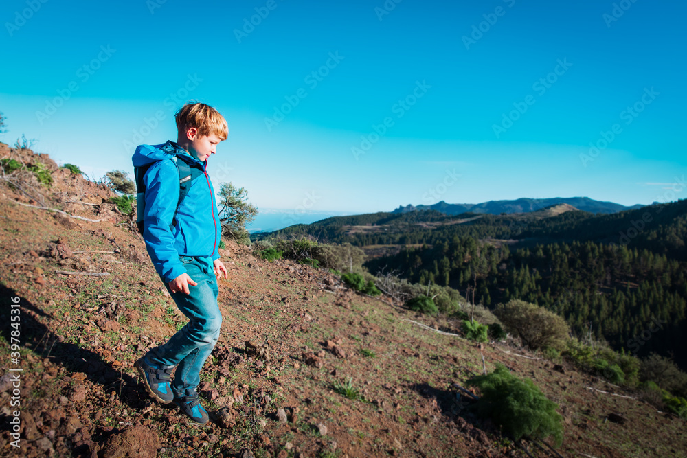 happy boy hiking in nature, kid travel in mountains