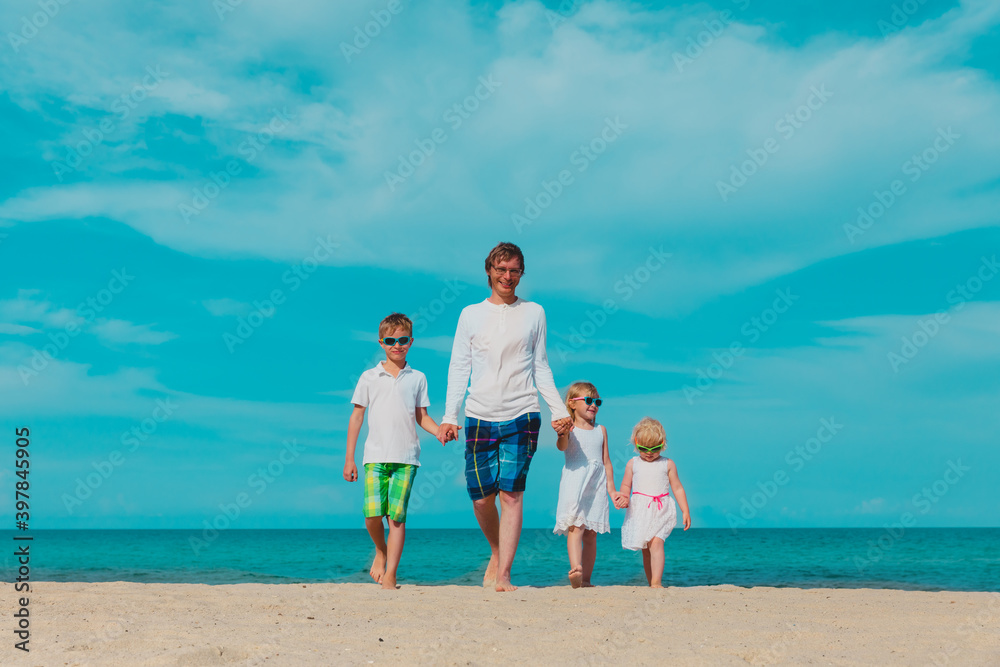 happy father and three kids walking on beach happy father and three kids walking on beach
