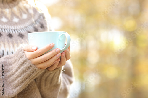 Woman hands holding coffee cup in winter