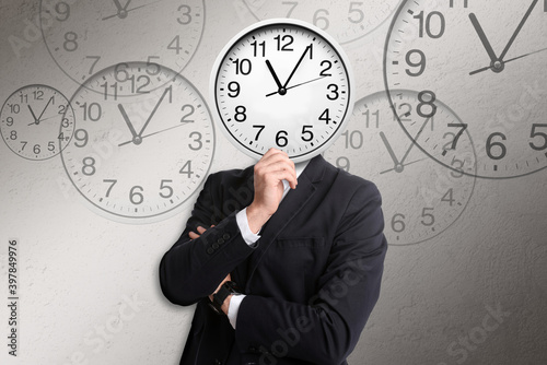 Time management concept. Businessman with clock instead of head on light grey background