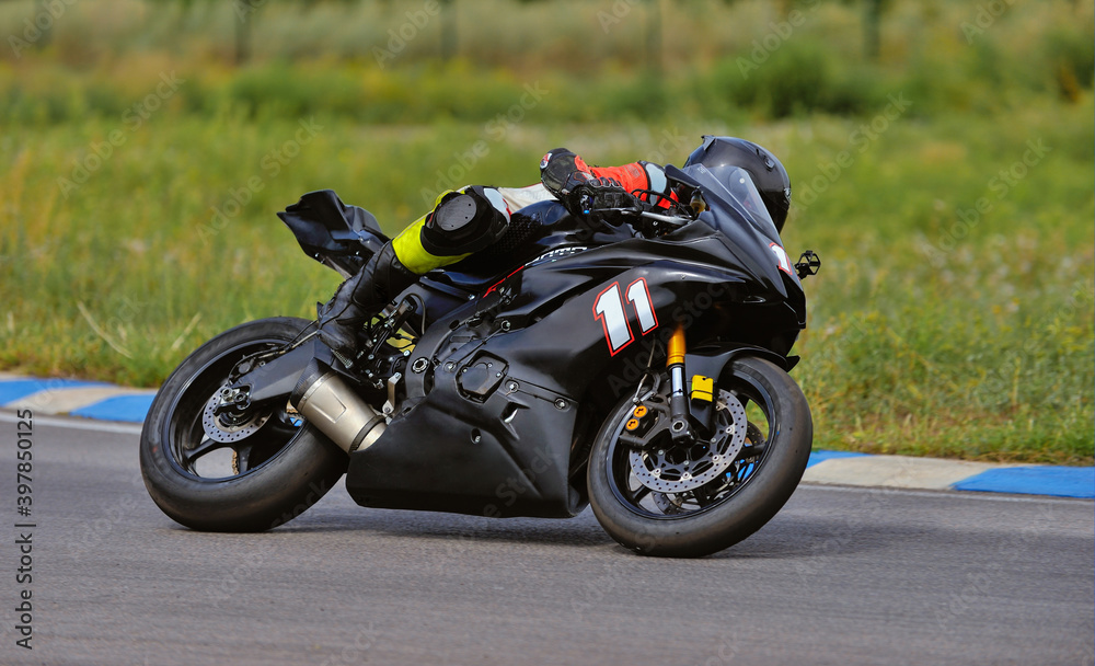 Motorcycle practice leaning into a fast corner on track Motorcycle practice leaning into a fast corner on track