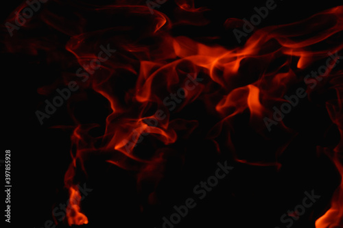 Abstract fire flame in fireplace, texture for background. Beautiful bright orange flames flicker in the darkness of the night.