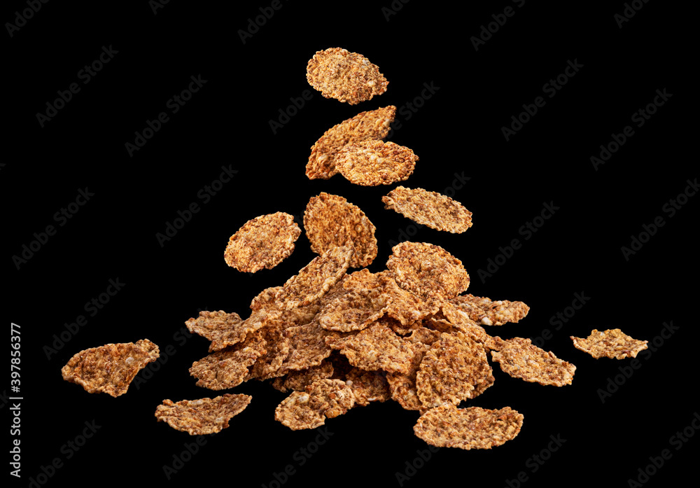 Fototapeta premium Falling bran flakes on black stone background