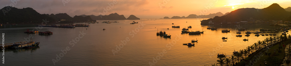 Sunset on Ha Long Bay with boats and floating dwellings
