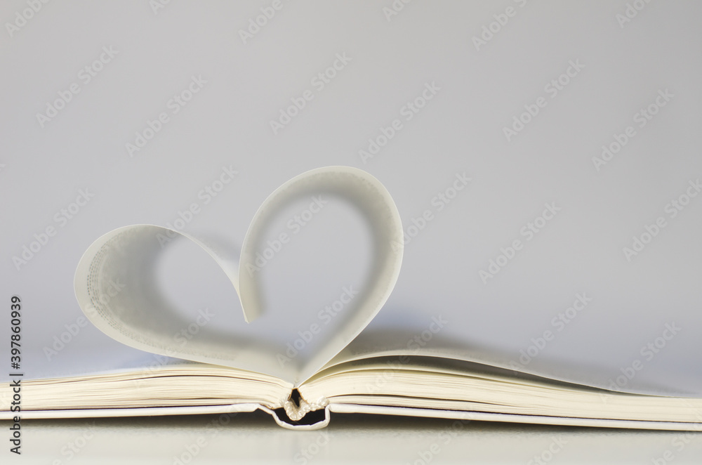 Close-up of book pages folded into a heart shape. Love of reading. Close-up of book pages folded into a heart shape. Love of reading.