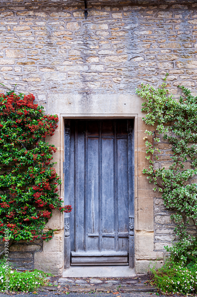 Step back in time and visit Castle Combs, quaint village with well preserved masonry houses dated back to 13 century. Very old weathered door in house in a picturesque medieval village in England. UK.
