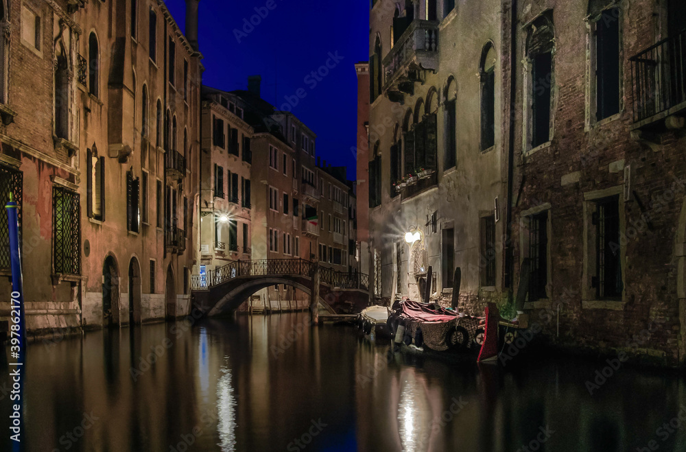 View of a small, romantic canal in Venice at night