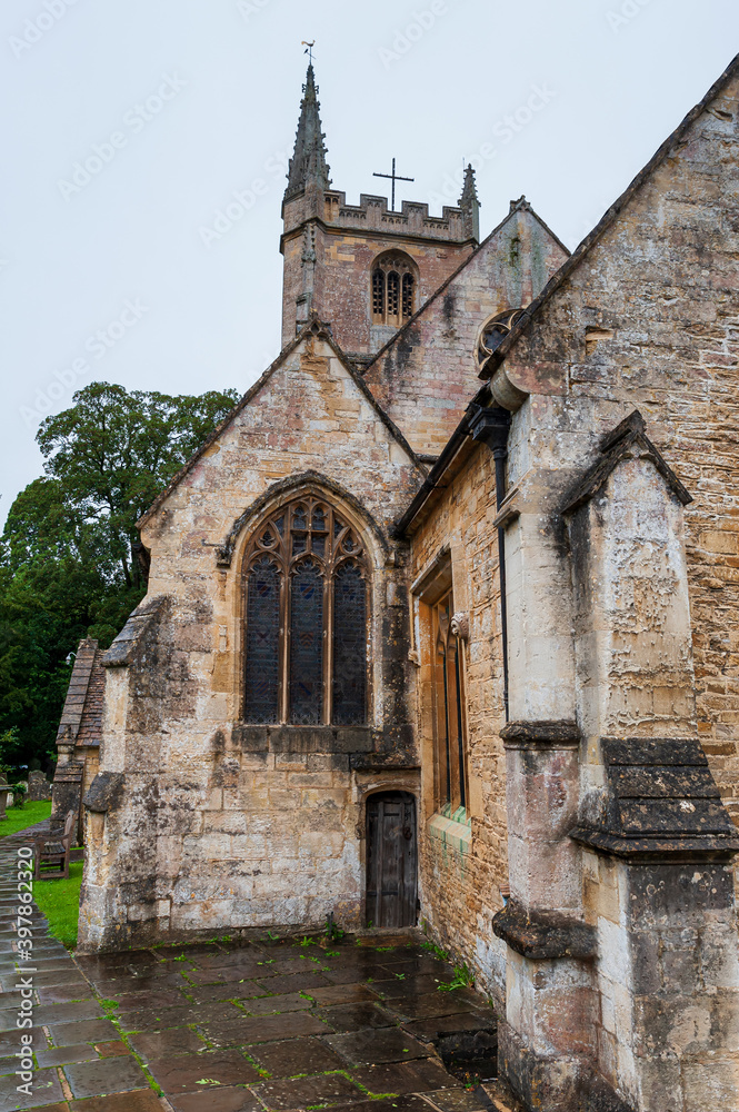 Naklejka premium Step back in time and visit Castle Combe, quaint village with well preserved masonry houses dated centuries back. St Andrew's Church with an old graveyard in picturesque medieval village in England.