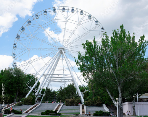 The "One Sky" Ferris Wheel is installed in the Revolution Park. Vacationers strolling along the paths