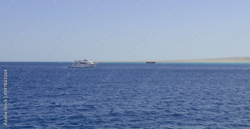 Egypt, Sinai, Sharm el-Sheikh, Red Sea, September 27, 2014: A white pleasure boat in the Red Sea off the coast of Sharm el-Sheikh, Egypt. A lot of people rest on the boat.