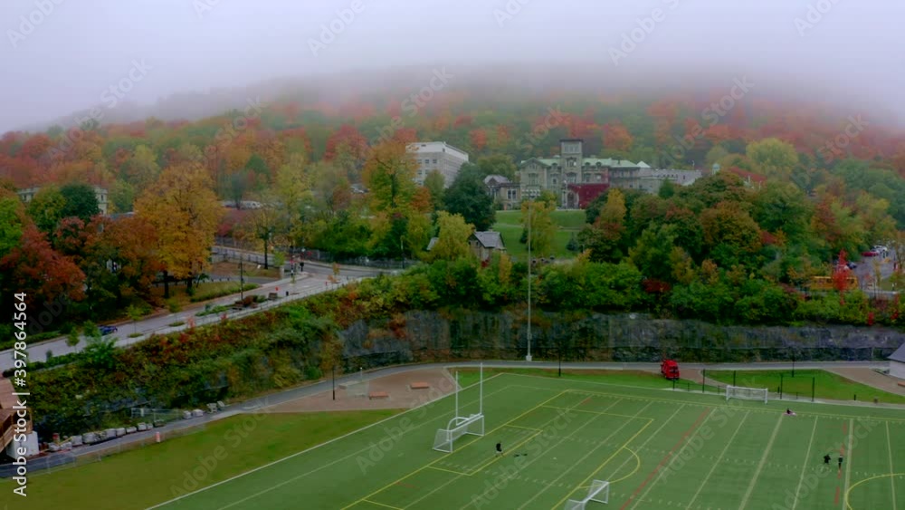 Drone going down on the side of a synthetic soccer field near the Mount-Royal mountain in Montreal on a foggy morning Drone going down on the side of a synthetic soccer field near the Mount-Royal mountain in Montreal on a foggy morning