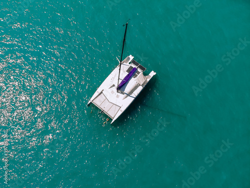 Picturesque top view of a huge white catamaran sailing across the deep sea. Aerial view. © Semachkovsky 