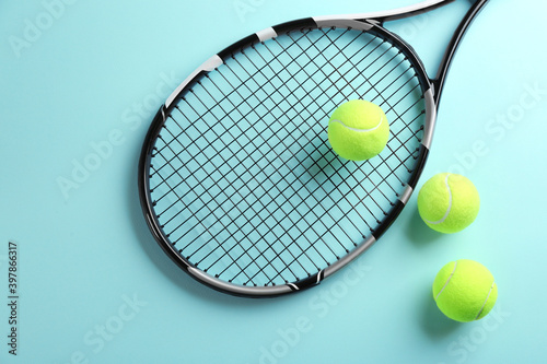 Tennis racket and balls on light blue background, flat lay. Sports equipment © New Africa