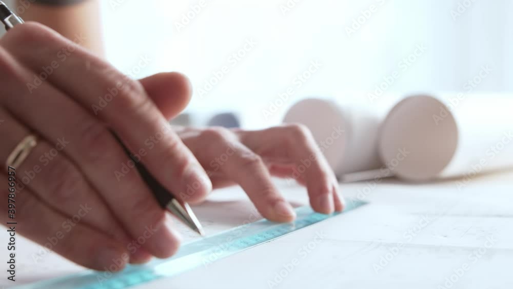 Close-up of an architect's hands. Professional real estate designer at the workplace in the office. Close-up of an architect's hands. Professional real estate designer at the workplace in the office.