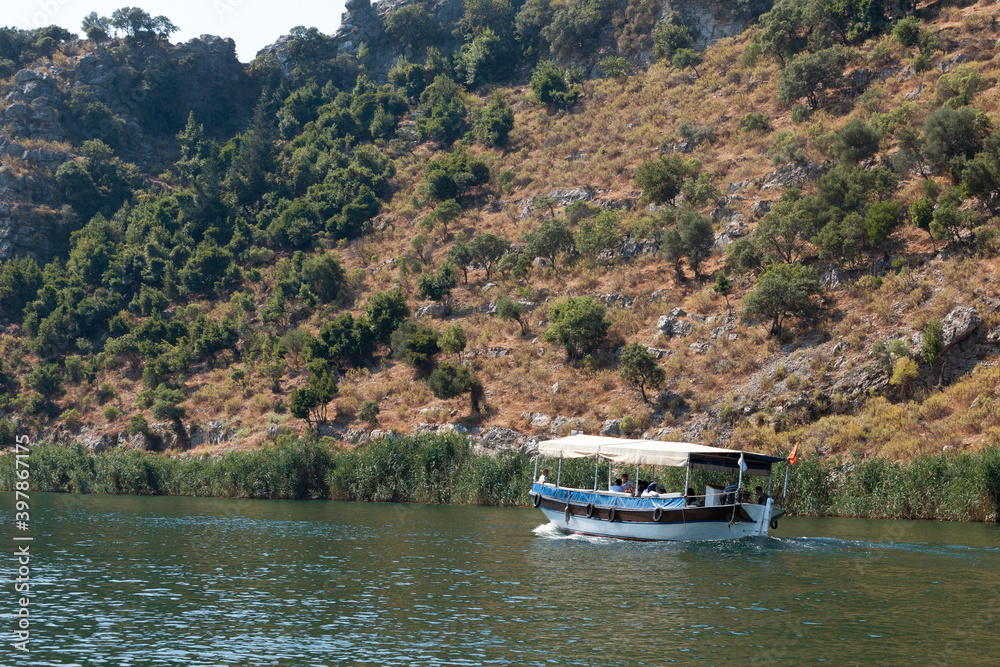 A small boat in a body of water with a mountain in the background