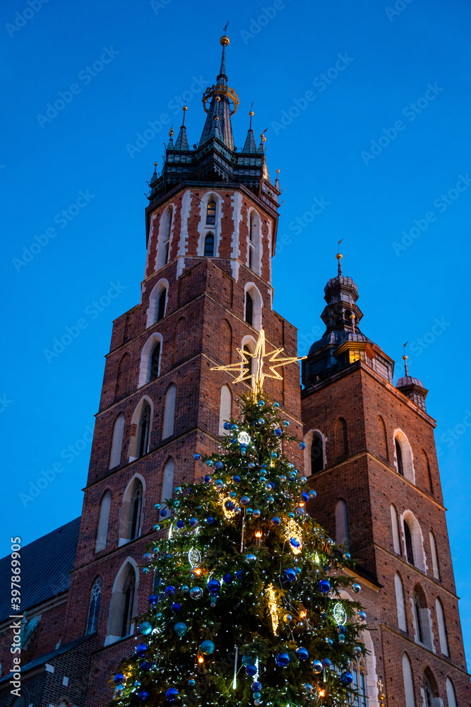 Big glowing decorated christmas tree standing in main market square, winter holidays, peoples enjoy.