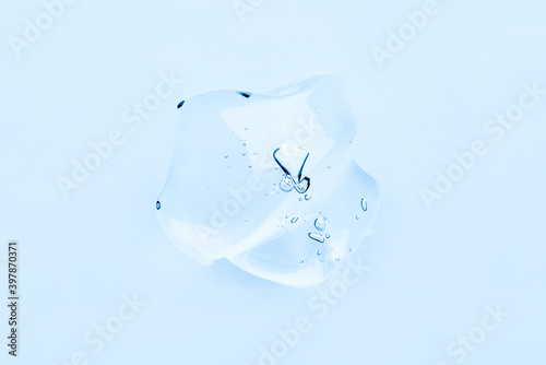 Transparent hyaluronic acid gel texture on a blue background.