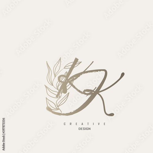 logo kk dengan warna emas, logo terinspirasi dari daun dan kuas.