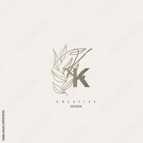 logo kk dengan warna emas, logo terinspirasi dari daun dan kuas.