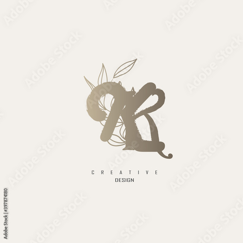 logo kk dengan warna emas, logo terinspirasi dari daun dan kuas.