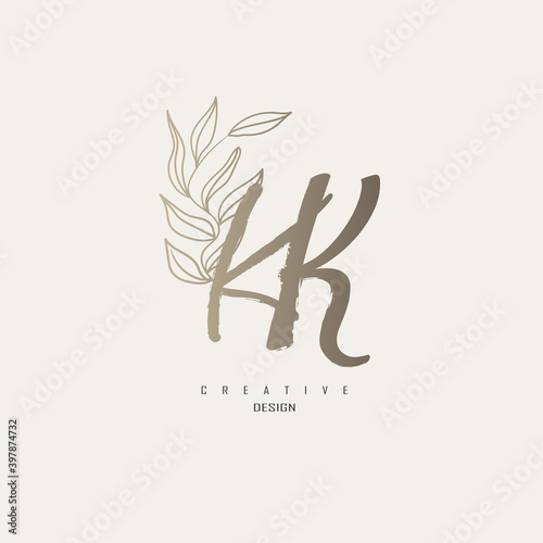 logo kk dengan warna emas, logo terinspirasi dari daun dan kuas.