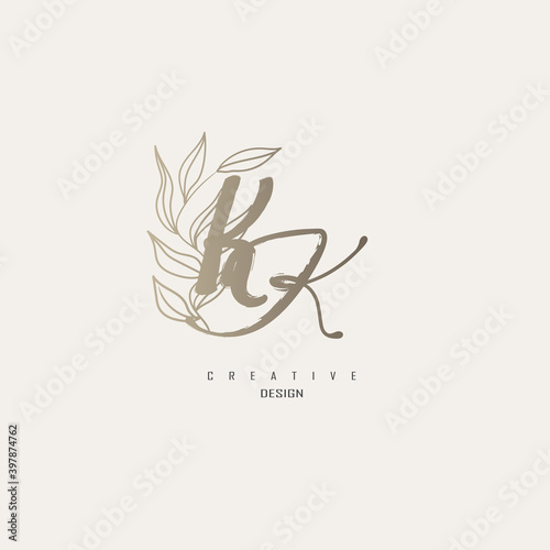 logo kk dengan warna emas, logo terinspirasi dari daun dan kuas.