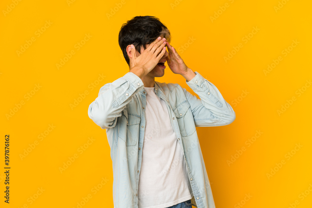 Young skinny hispanic man afraid covering eyes with hands. Young skinny hispanic man afraid covering eyes with hands.